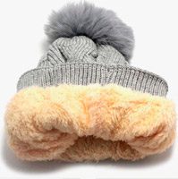 Gorro de lã cinza com a a borda virada exibindo o forro de pelo bege. Os gorros de frio forrados são perfeitos