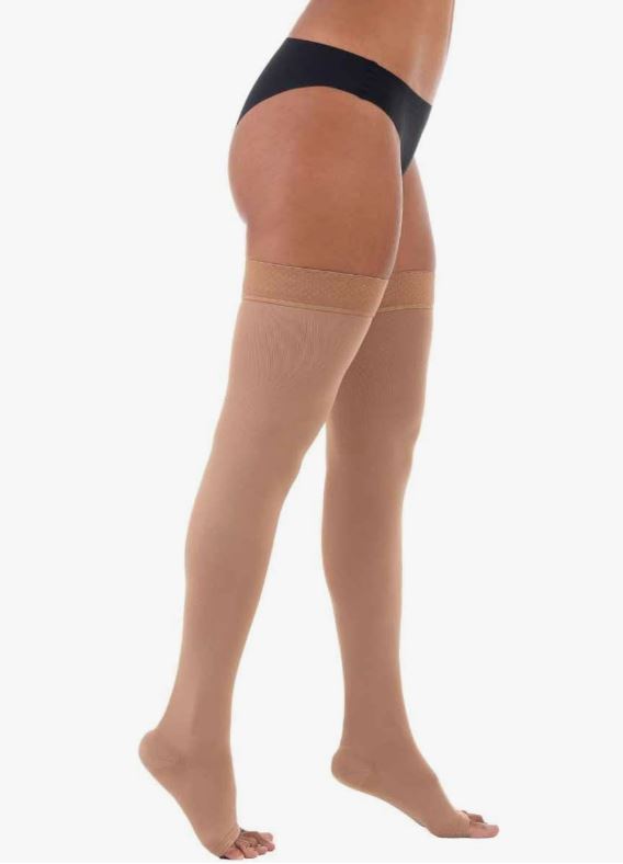 Corpo de mulher da cintura para baixo com meias de compressão cor da pele, meia coxa da marca Venosan Ultraline com conforto climático